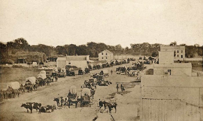 Covered wagons in early day Manhattan, Kansas.