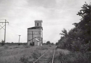Railroad shed depot and a grain elevator in Palestine, Kansas, by H. Killam, 1964.