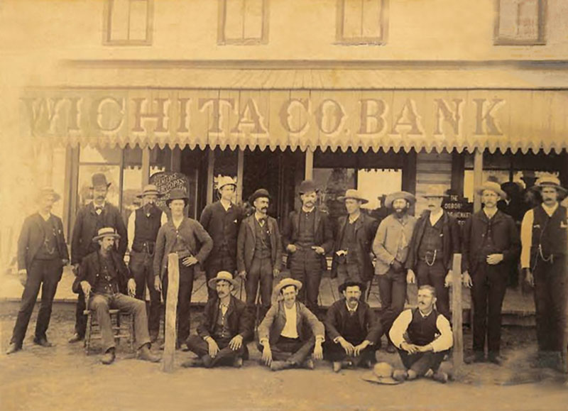 Dodge City men posing in front of Wichita County Bank, in Coronado, Kansas. Dodge City men posing in front of Wichita County Bank, in Coronado, Kansas.